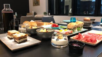 A buffet table with various dishes including pastries, salads, and meats.