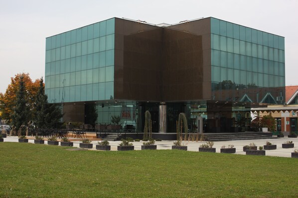 A modern building with a glass facade and a central entrance. - Hotel Cubis (Lendava)