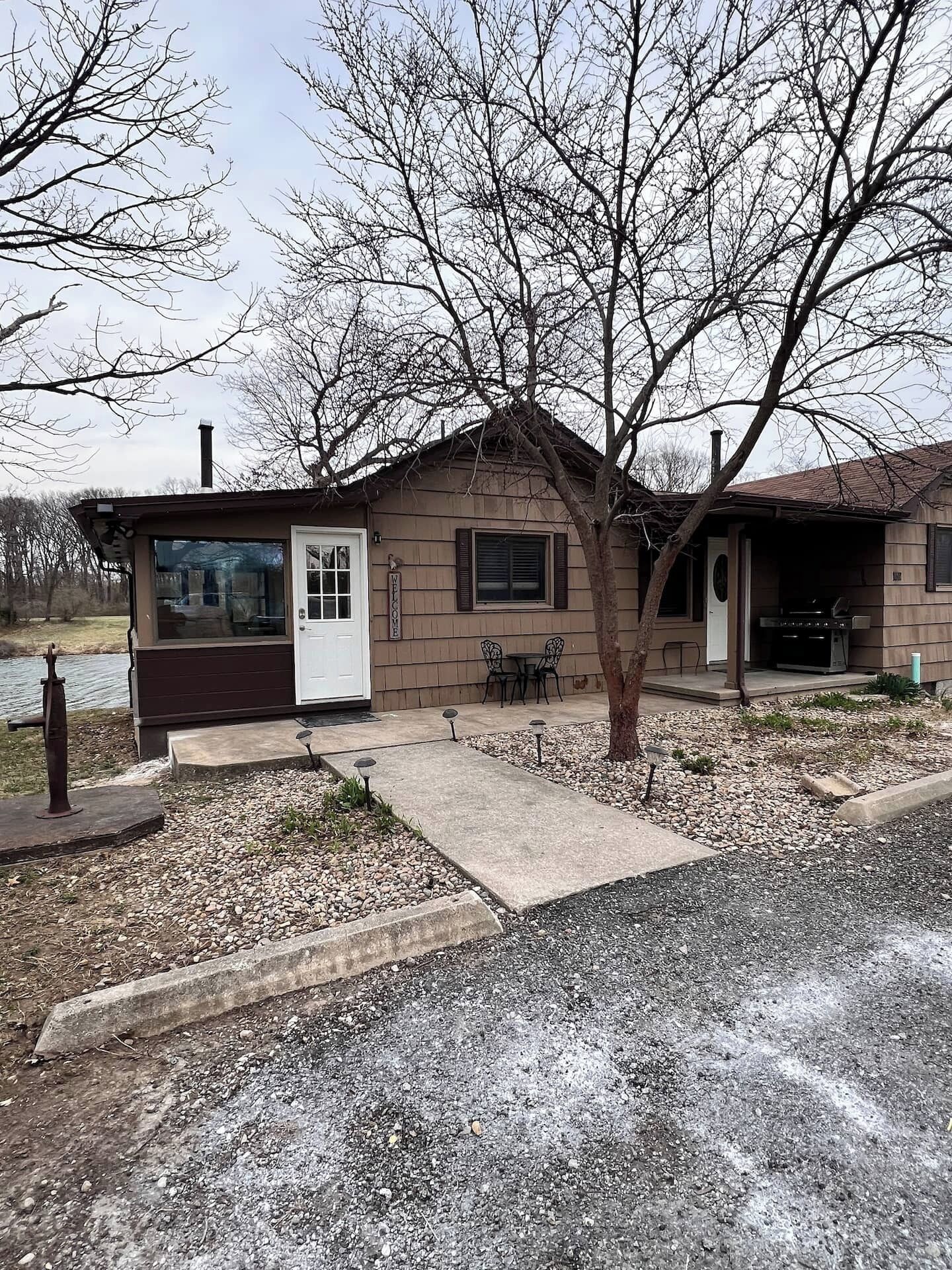 A single-story house with a front porch, a small patio area, and a visible garage.