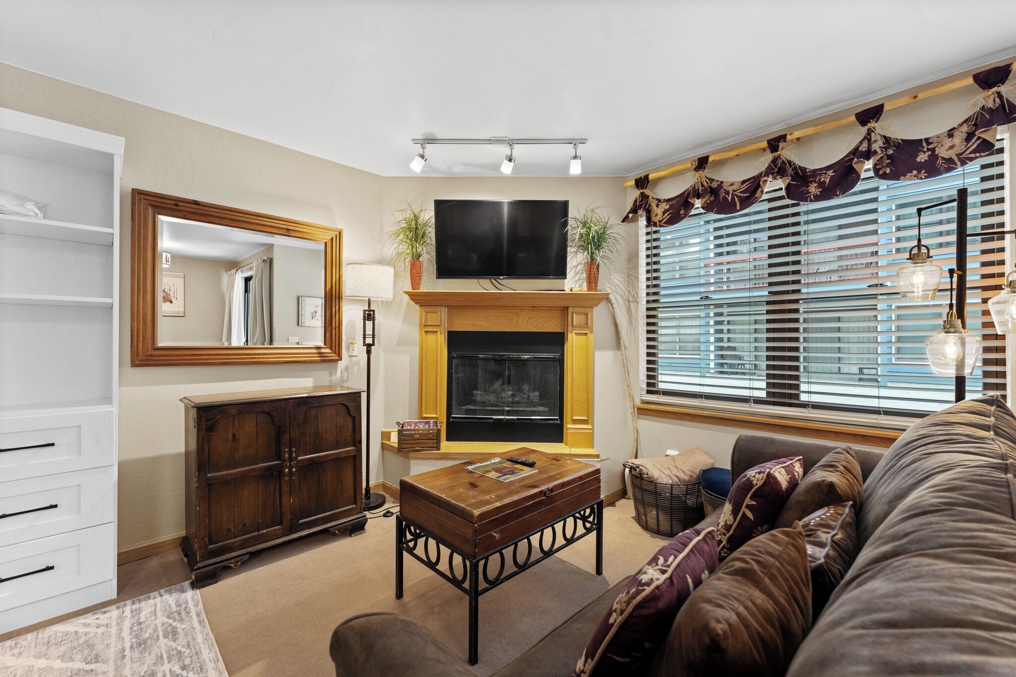 Unwind in your cozy living space with plush leather seating, crackling fireplace, and warm wood accents creating the perfect retreat.