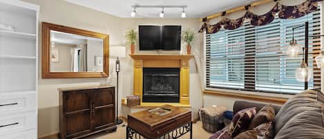 Unwind in your cozy living space with plush leather seating, crackling fireplace, and warm wood accents creating the perfect retreat.