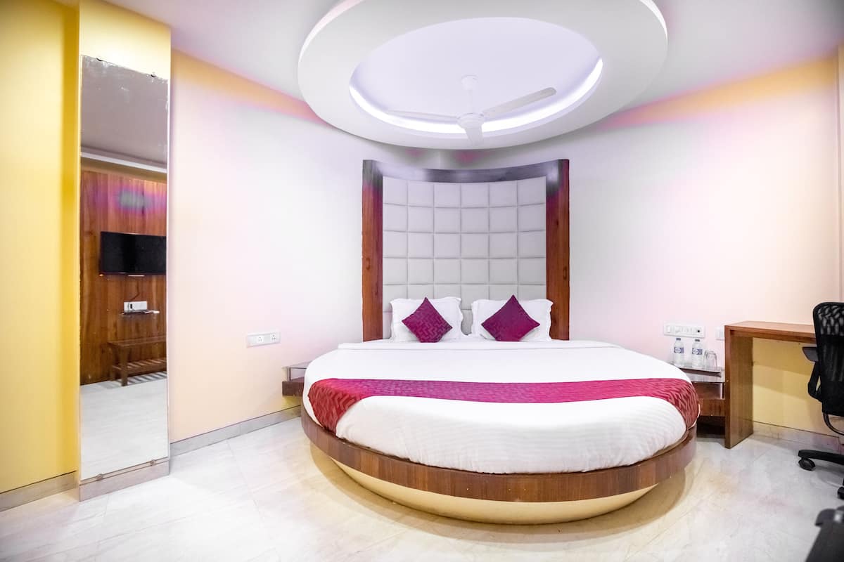 A modern bedroom with a circular bed, a ceiling fan, and a bedside table with a lamp.