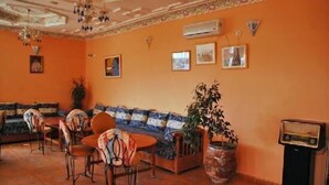 Une pièce comprenant un ensemble de canapés, des fauteuils, une table et une plante en pot.