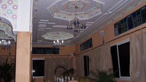 Une pièce dotée d’un plafond décoratif, de grandes fenêtres et d’un lustre.