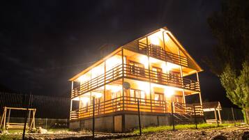 Ein zweistöckiges Holzhaus mit Balkon und Treppe zum Obergeschoss.