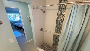 A shower with a glass door, a towel rack, and a toilet. - Honu Cove (Age 16+) (Deerfield Beach)