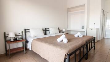 A hotel room with a bed, a nightstand, a lamp, and a wall-mounted control panel.