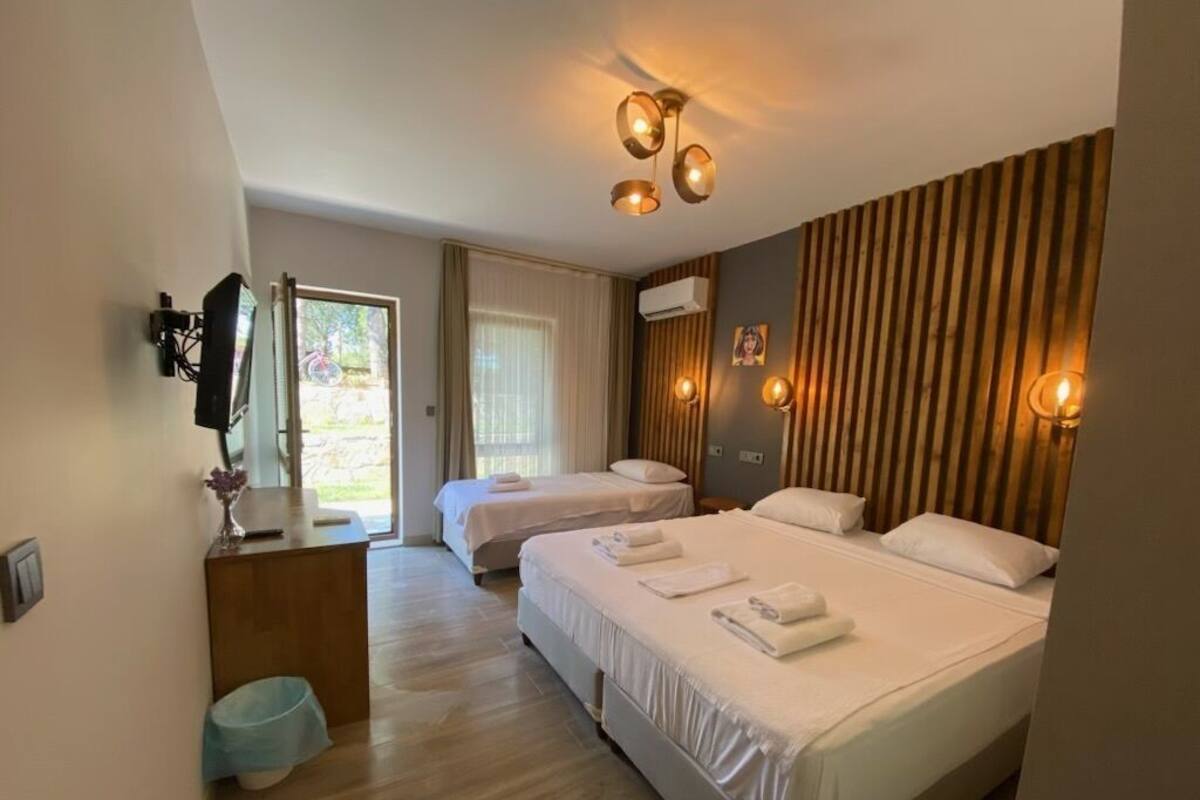 Een hotelkamer met twee bedden, een badkamer en uitzicht op de omgeving.
