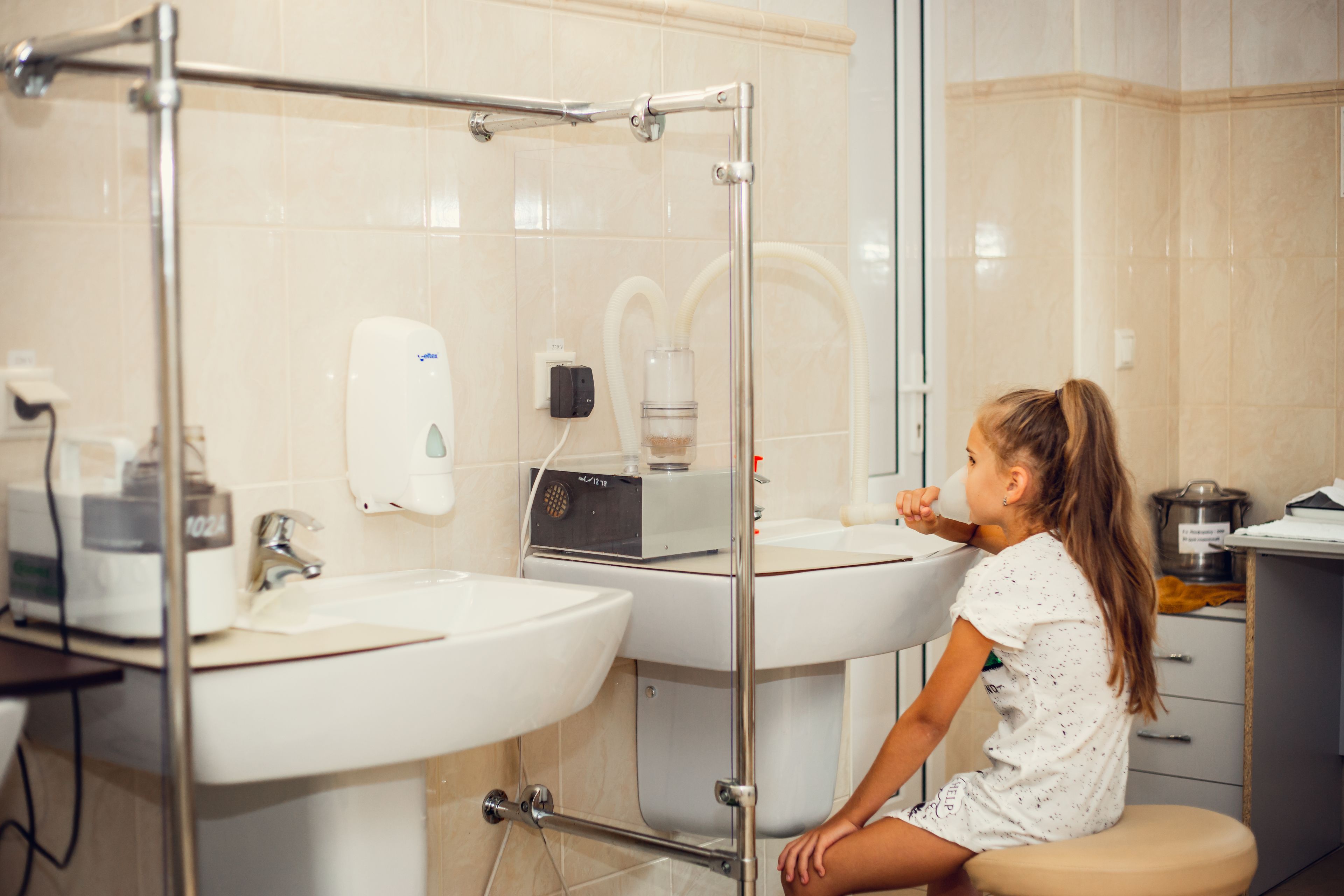 A bathroom with a glass shower enclosure, a sink, and a toilet.