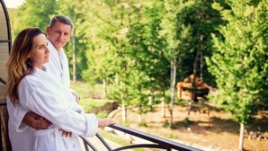 A couple standing on a balcony with a view of a landscaped garden. - Solva Resort & SPA (Poliana)