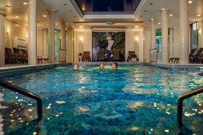An indoor swimming pool with clear blue water, surrounded by columns and lounge chairs. - Solva Resort & SPA (Poliana)