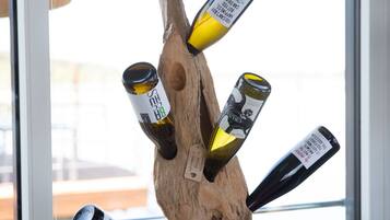 Una dispensa in legno con diverse bottiglie di vino davanti a una finestra.