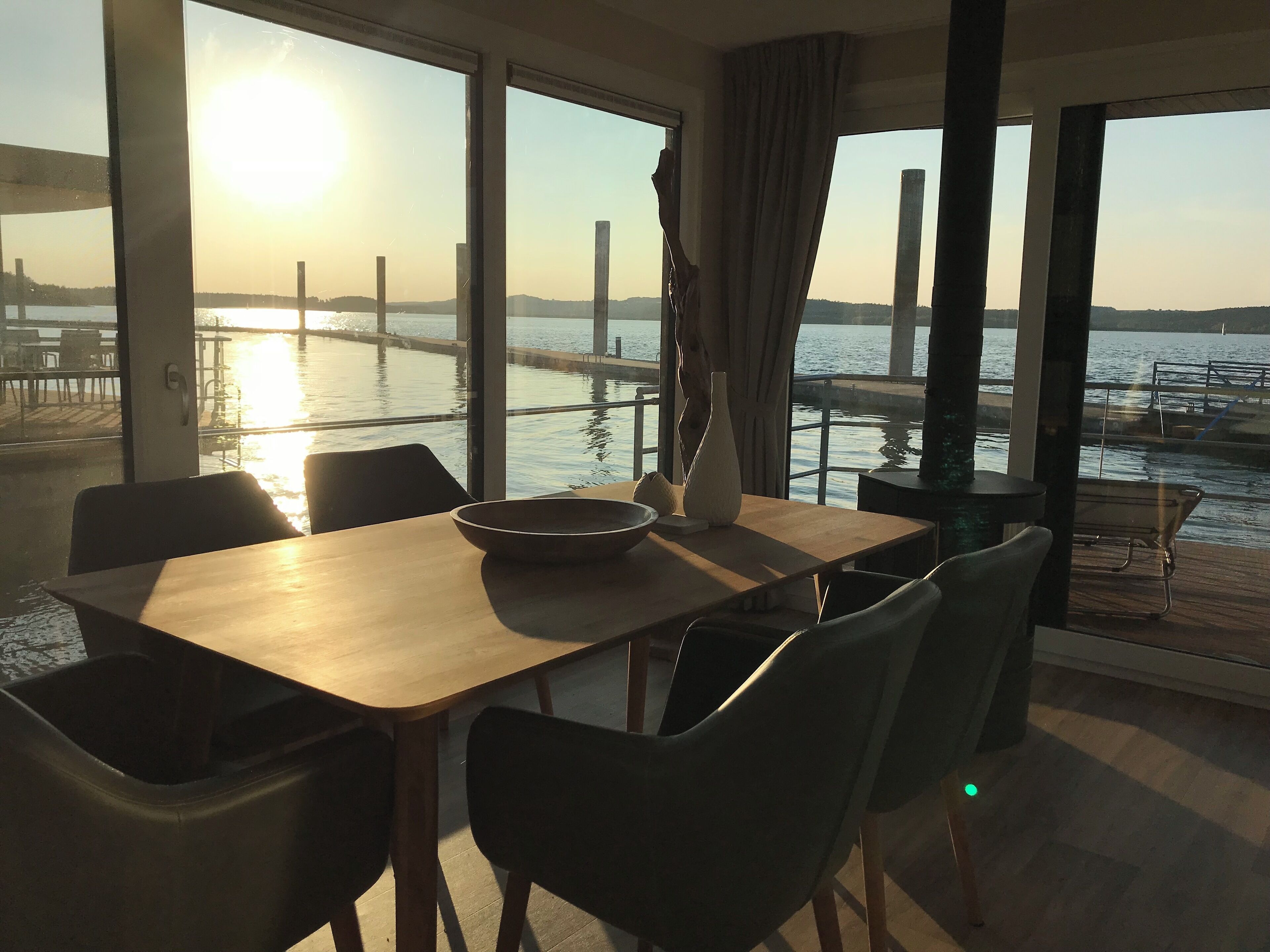 Un comedor con vista al agua y un muelle al fondo.