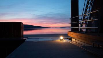 Vista al agua con muelle, estructura de madera y escalera de metal.