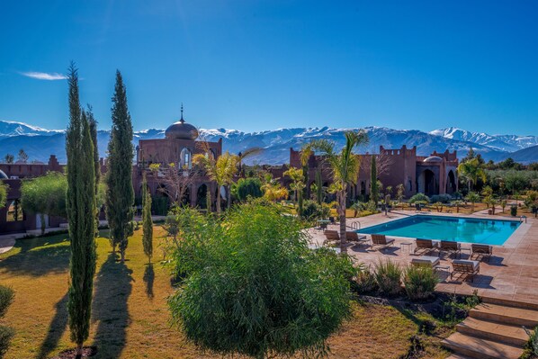 Relax by the serene pool surrounded by lush gardens and majestic mountain views.