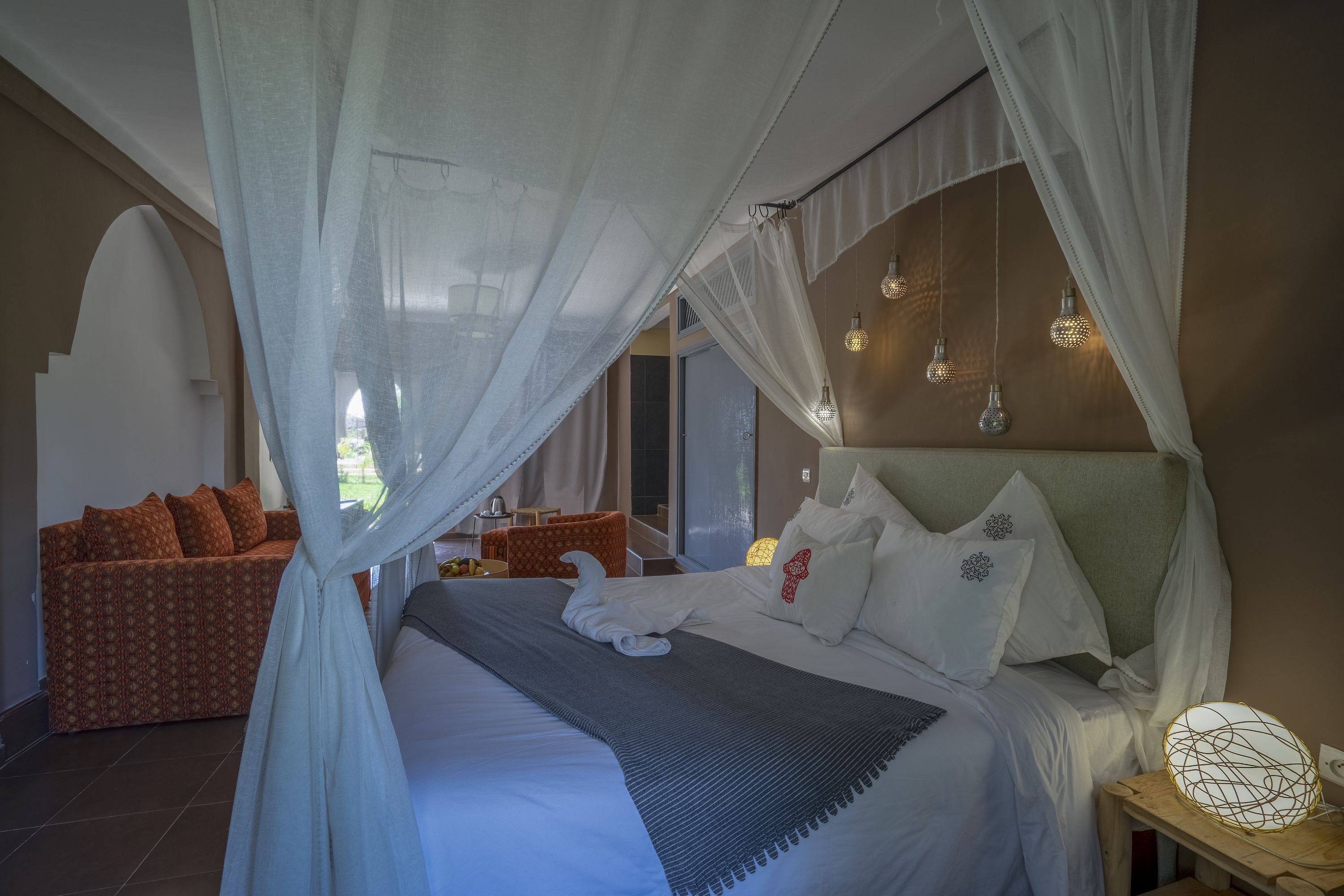 Une chambre à coucher avec un lit, un canapé et une table de chevet avec une lampe.