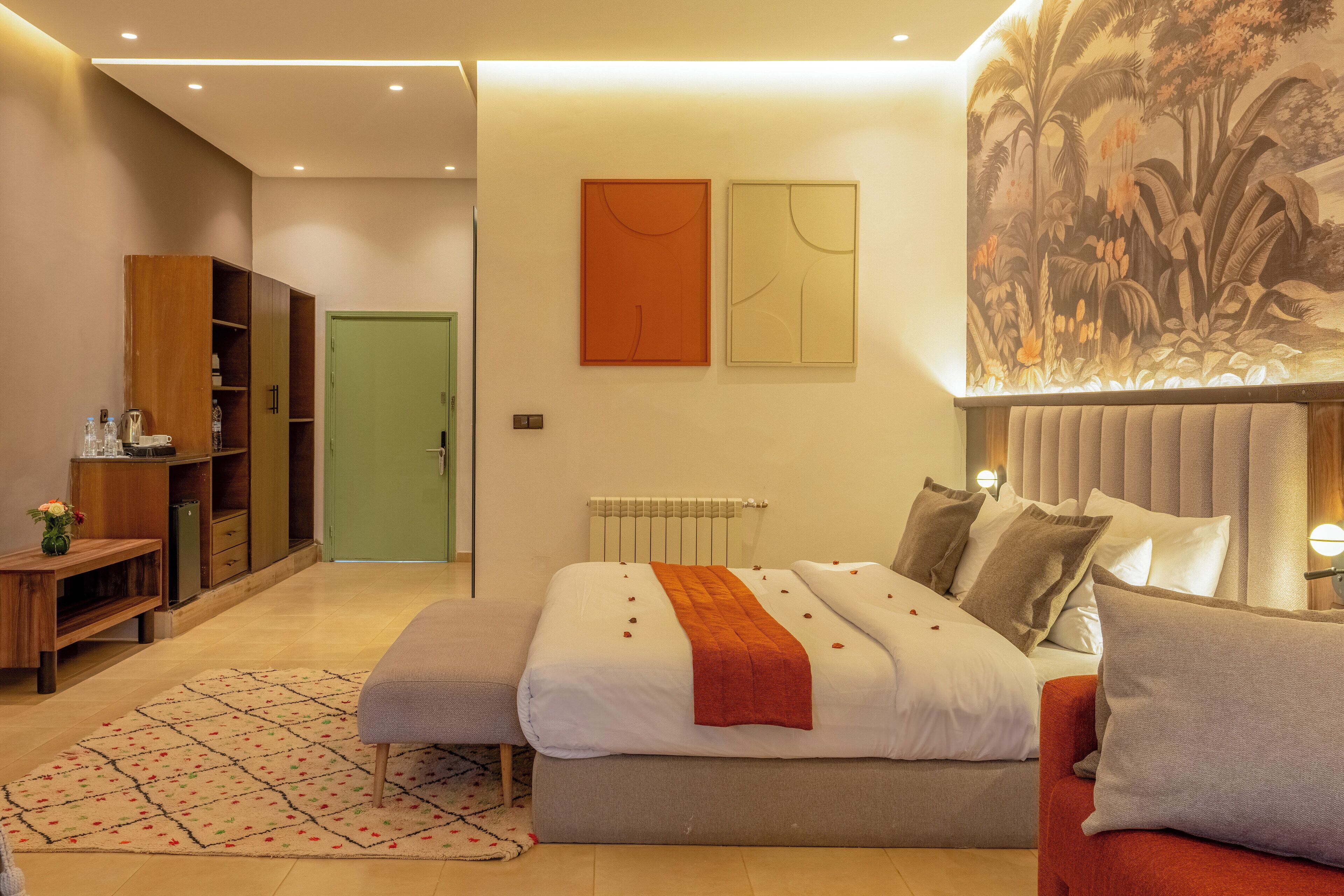 Ein modernes Schlafzimmer mit einem Bett, einem Nachttisch, einer Kommode und einer grünen Tür.