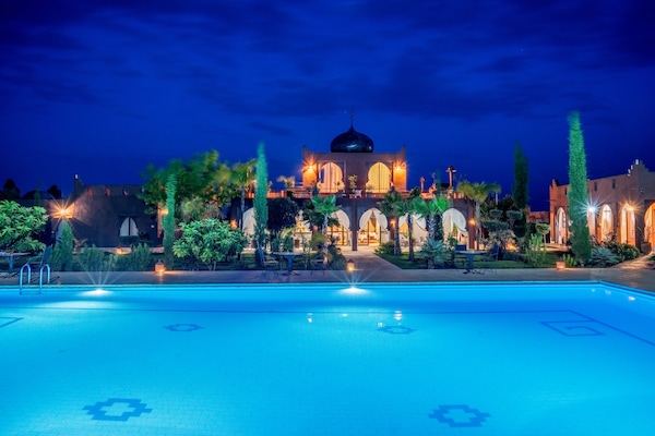 Una piscina al aire libre, sombrillas, sillones reclinables de piscina
