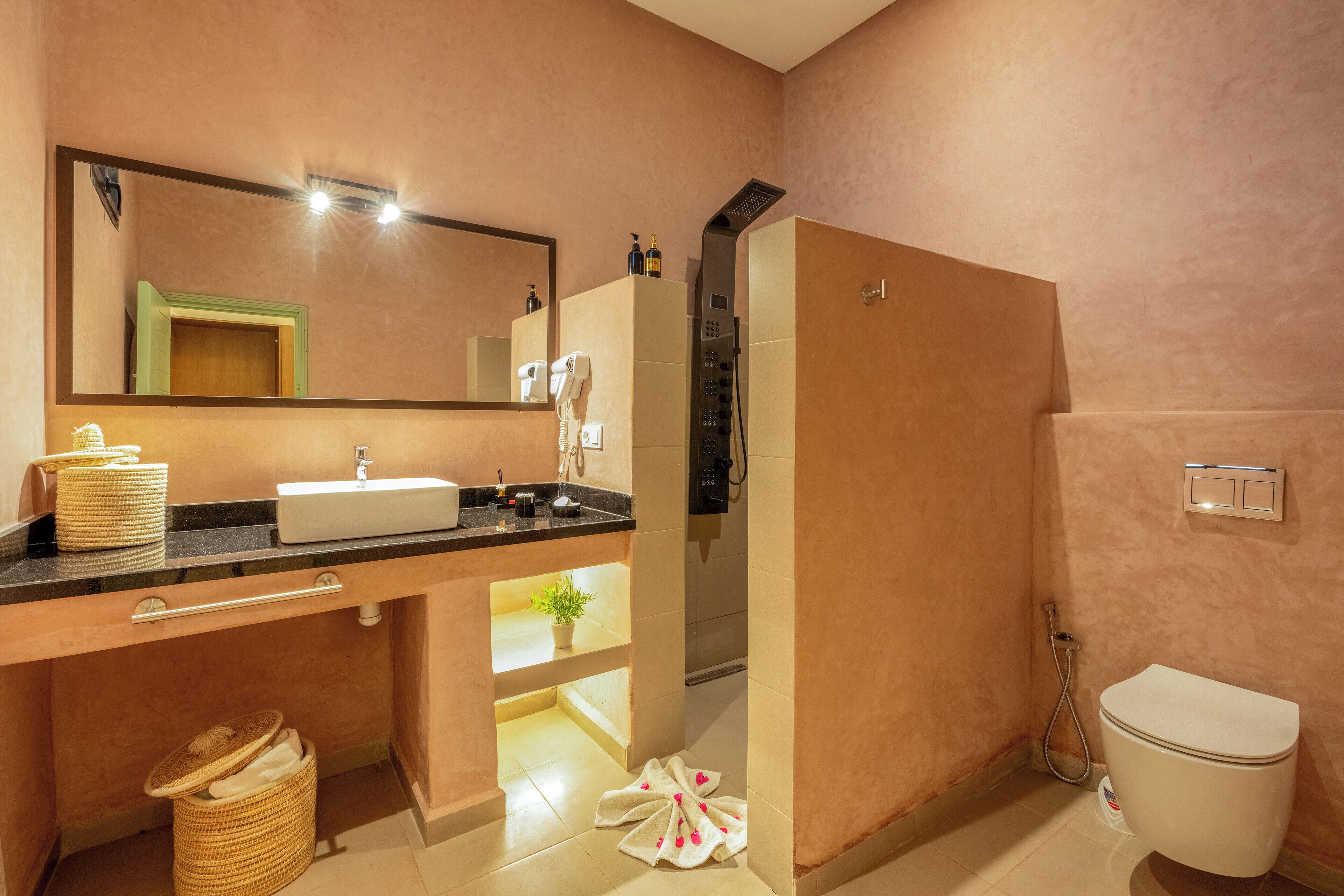 A modern bathroom with a sink, mirror, and toilet.