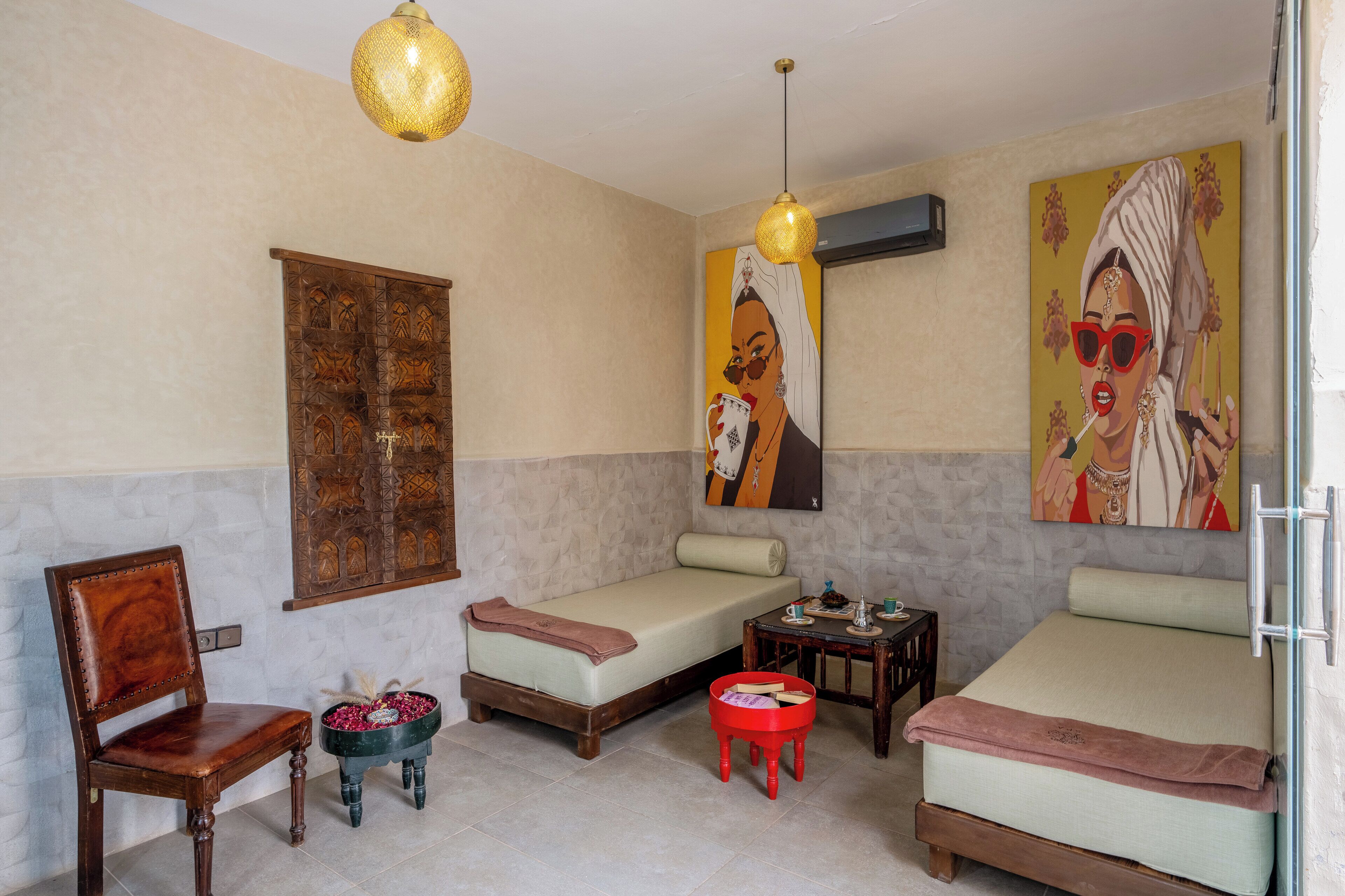 A room with a bed, a chair, a small table, and a decorative bowl.