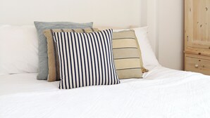 A bed with white bedding and striped pillows. - 2 bedroom accommodation in Whitstable (Whitstable)