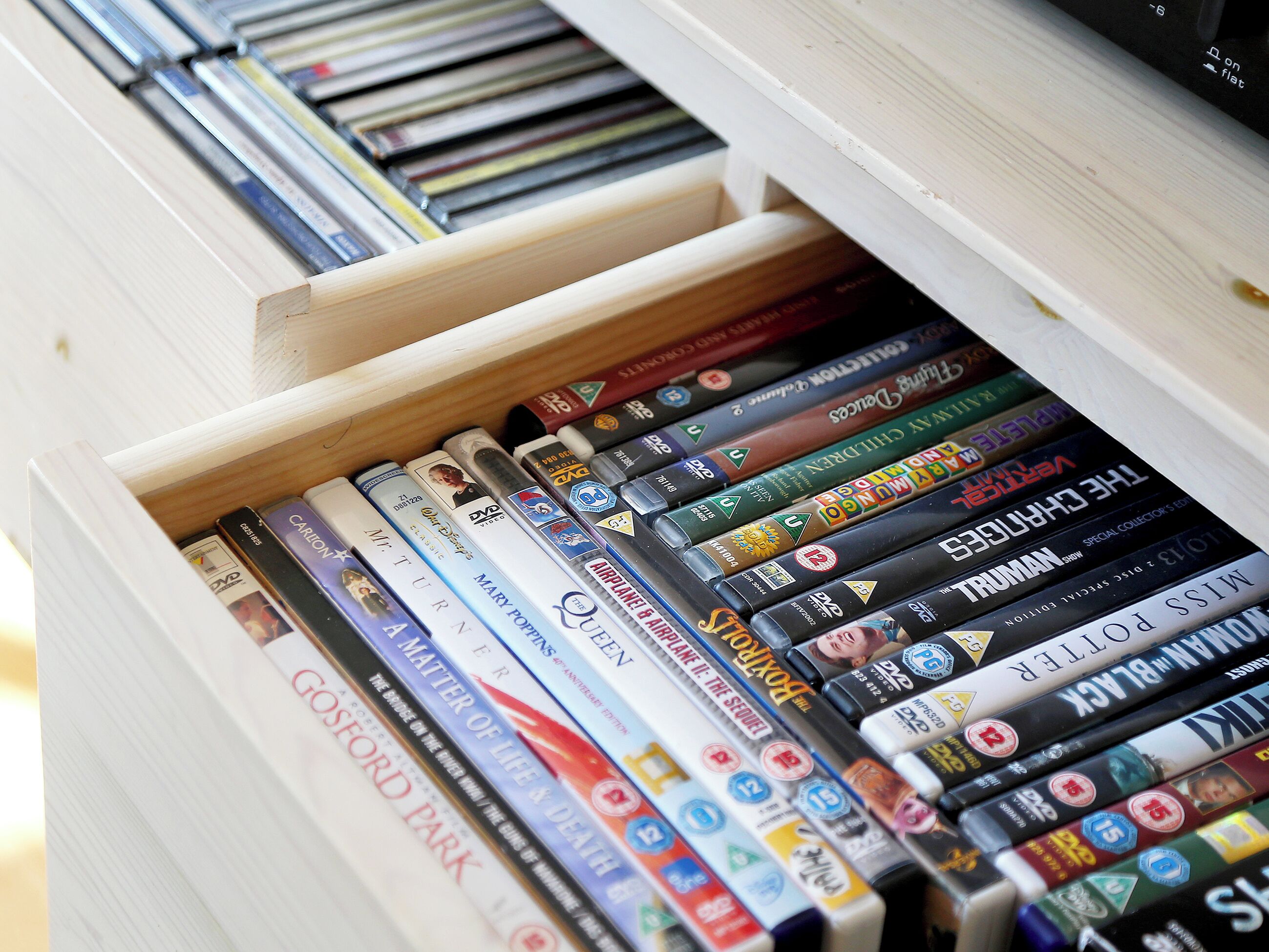 Een lade gevuld met dvd's en boeken, waaronder titels als 'The Lord of the Rings' en 'The Hobbit'.