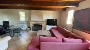 TV connectée, cheminée, table de tennis de table, livres