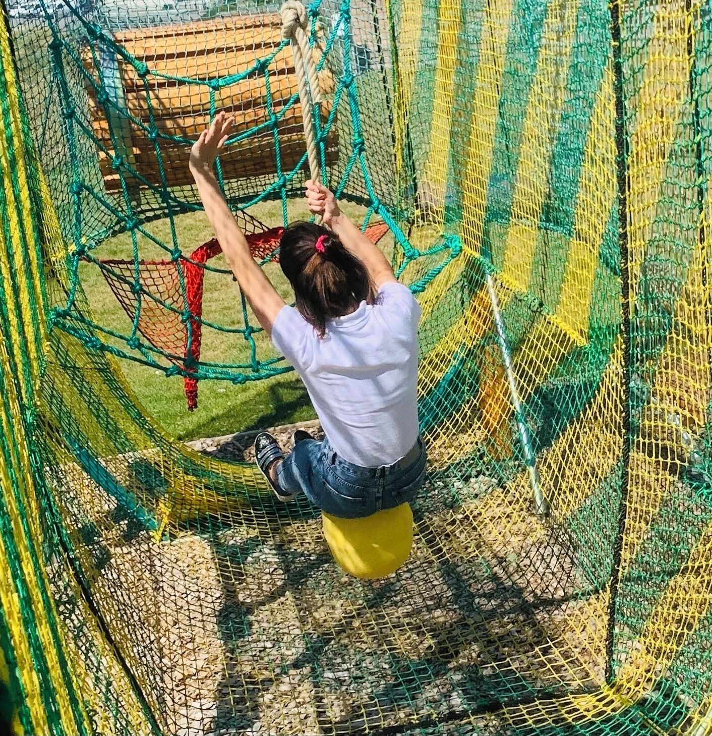 Una persona escalando una estructura de red.