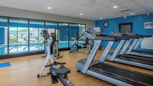 Ein Fitnessstudio mit Laufbändern, Crosstrainern und Rudergeräten.