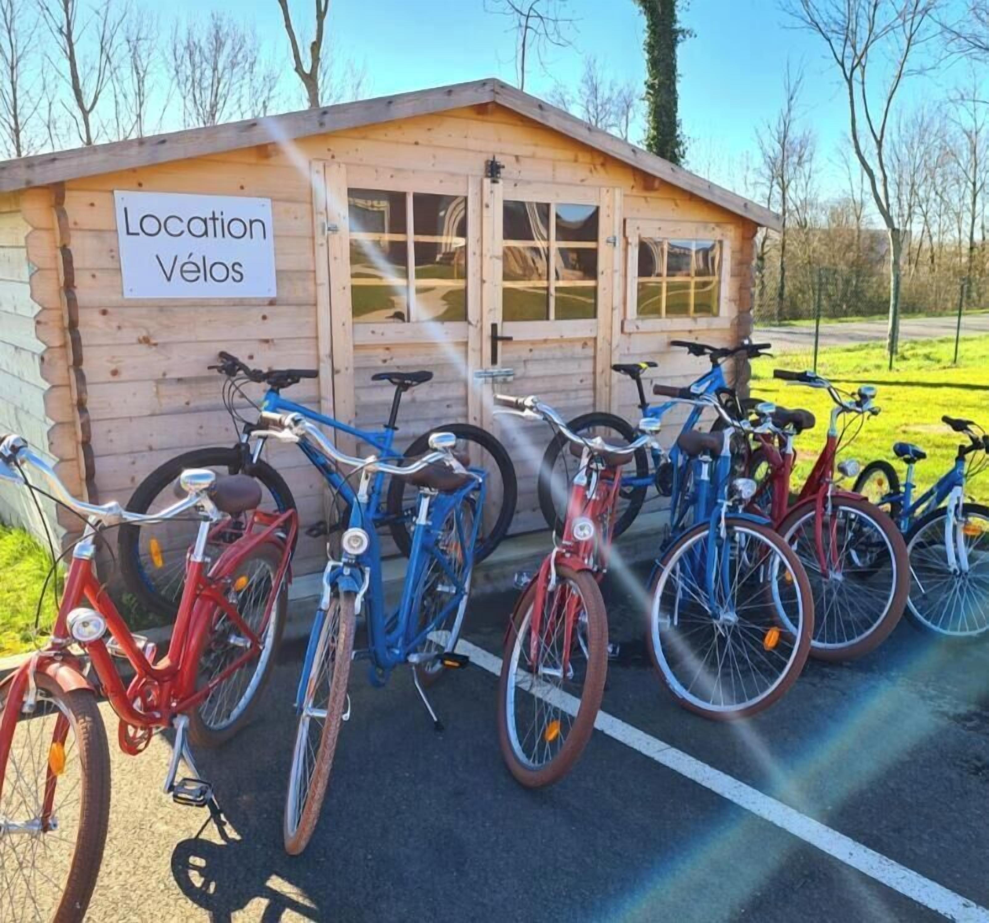 A wooden shed labeled "Location Vélos" with bicycles parked in front.