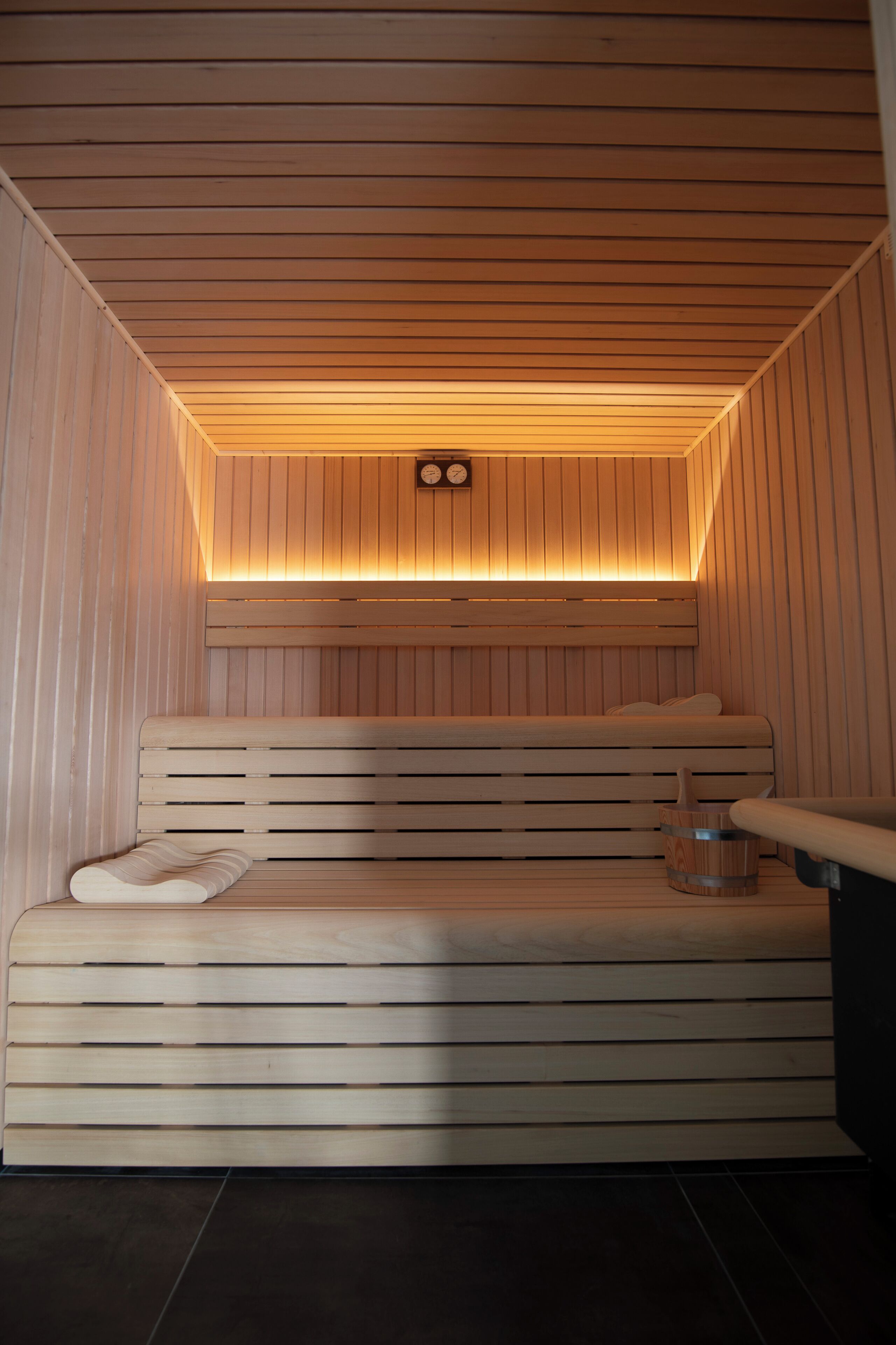 Een sauna met houten banken en een schuin dak.
