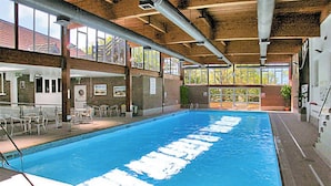 An indoor swimming pool with clear water, surrounded by a tiled floor and wooden beams on the ceiling. - 3 bedroom accommodation in Cromer (Cromer)