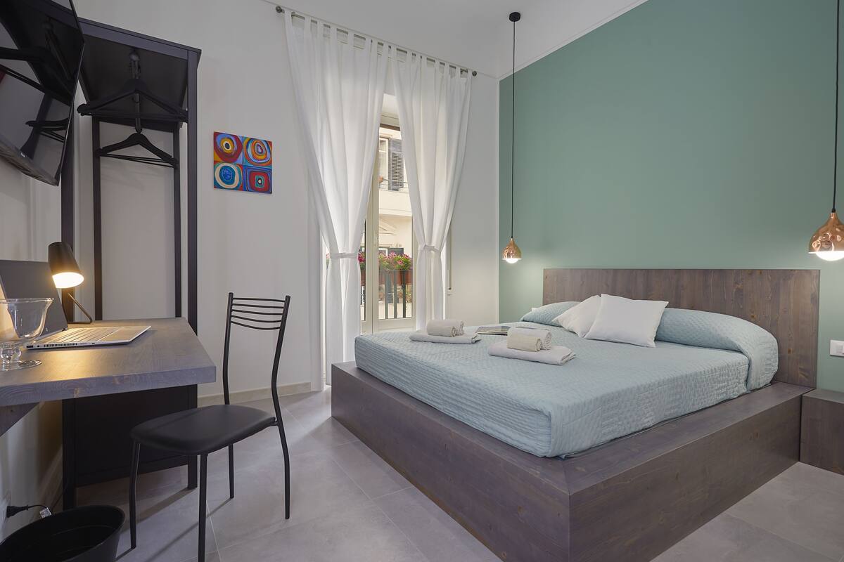 A modern bedroom with a bed, a desk, and a chair.