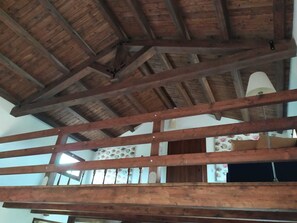 A wooden ceiling with exposed beams and a hanging light fixture. - MammaColette (Marsala)