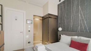 Une chambre d’hôtel équipée d’un lit, d’une armoire et d’une porte dotée d’un panneau de commande.