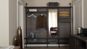 Une pièce compacte dotée d’une armoire intégrée, d’un miroir et d’un coin salon.
