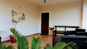 A room with a tiled floor, a bench, a table, and potted plants. - Zama Bed&Breakfast (Scalea)