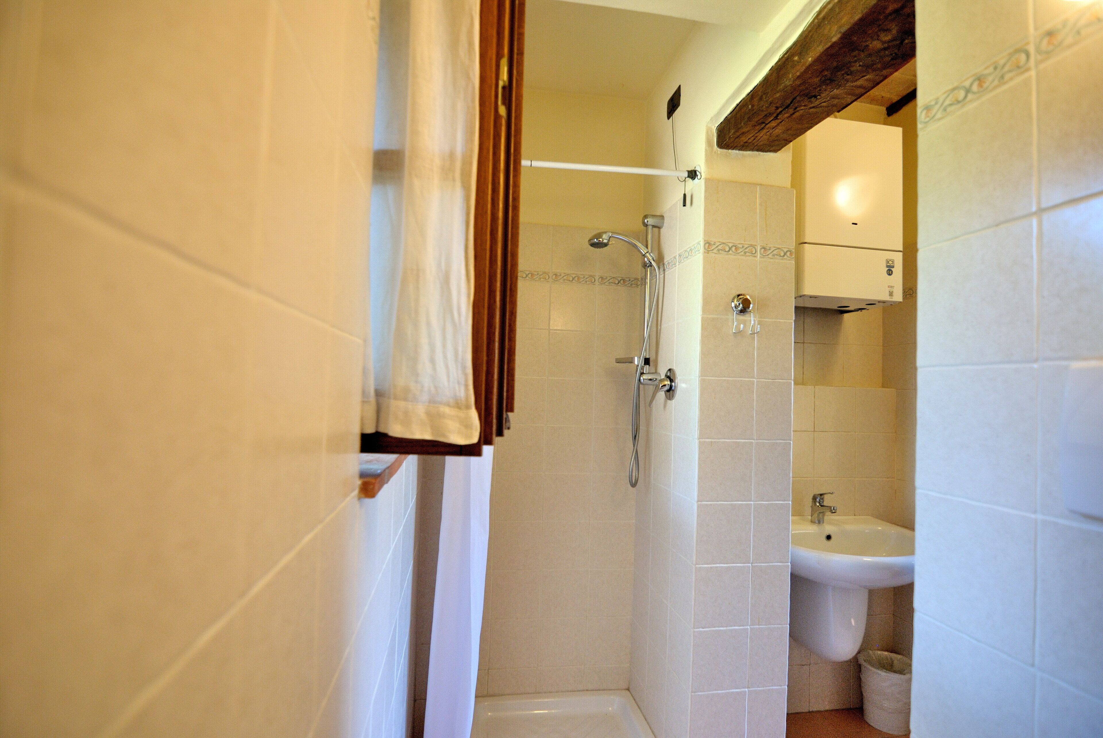 Une salle de bain avec une douche, un lavabo et des toilettes.