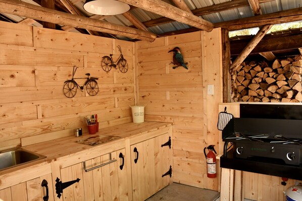 Una cocina de madera con estufa empotrada, armarios de madera y una bicicleta colgada en la pared.