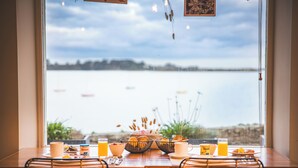 Een eettafel met ontbijtartikelen en uitzicht op een meer.