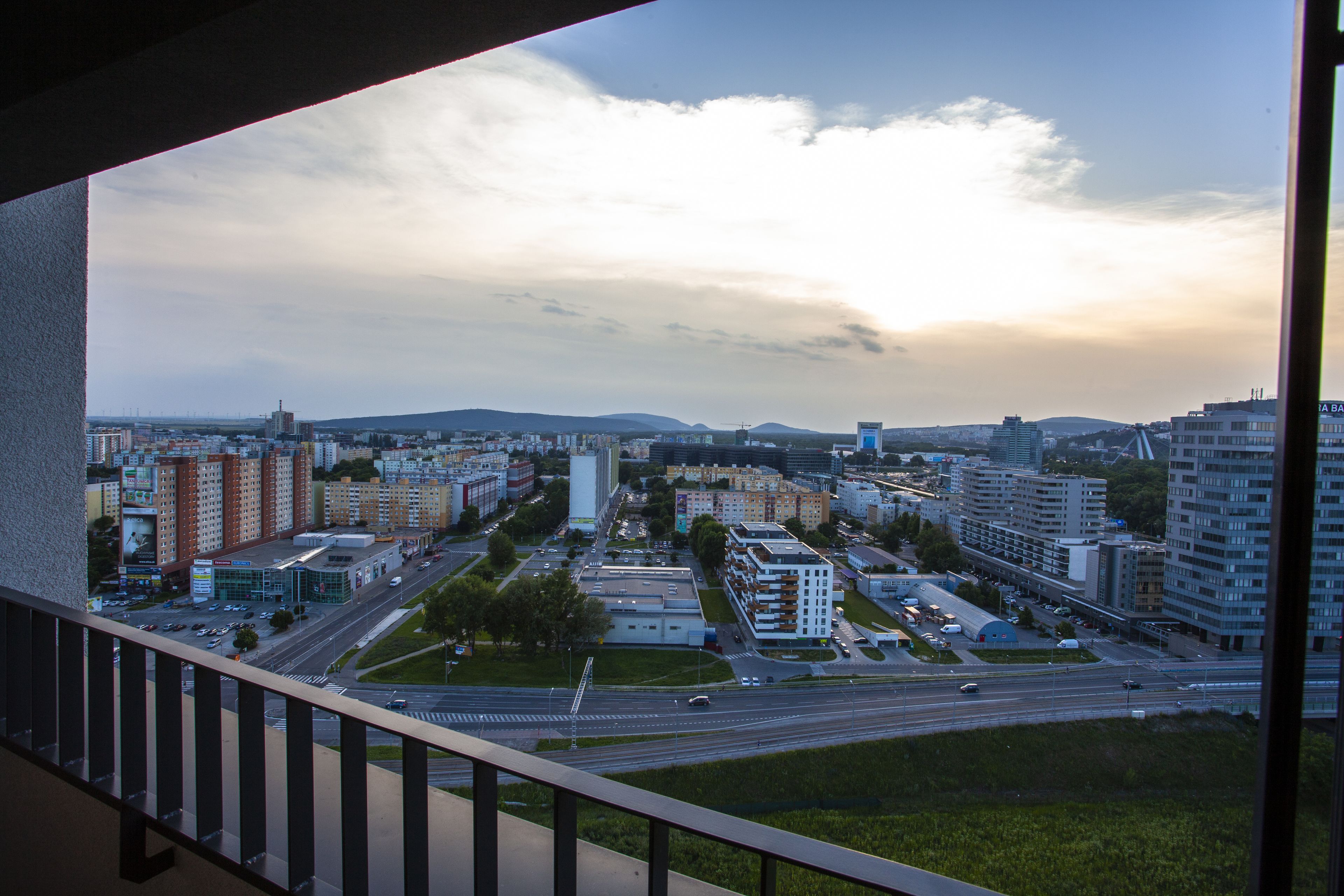 A cityscape with modern buildings, a highway, and a clear sky.