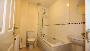 A bathroom with a bathtub, toilet, and sink.