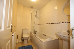 A bathroom with a bathtub, toilet, and sink. - Beautiful 4 beds Hillview House (London)