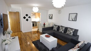 Un salon moderne comprenant un canapé, une table basse et un coin repas avec des chaises.