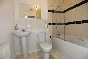 A bathroom with a sink, toilet, and bathtub.