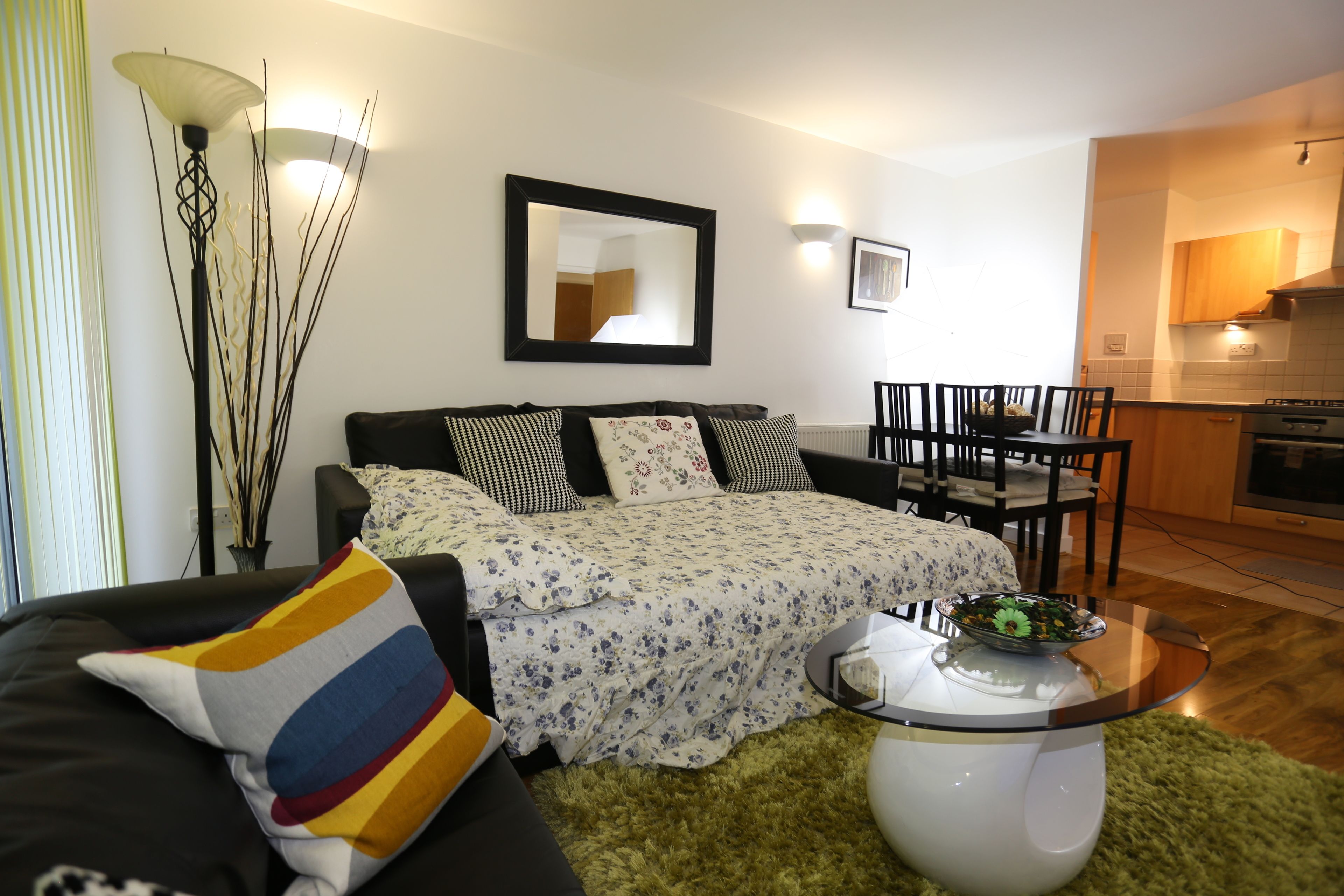 Una sala moderna con un sofá, una mesa de centro y una zona de comedor con sillas.
