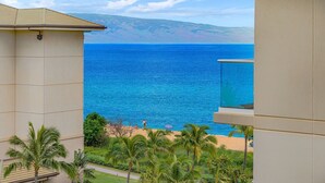 A balcony with a view of the ocean and a beach.