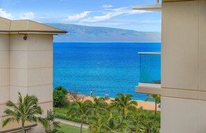 A balcony with a view of the ocean and a beach.