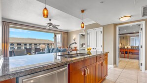 A modern kitchen with a large island, stainless steel appliances, and pendant lighting.