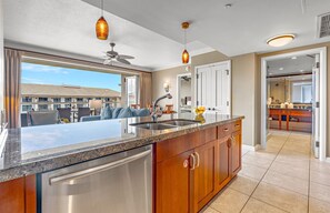 A modern kitchen with a large island, stainless steel appliances, and pendant lighting.